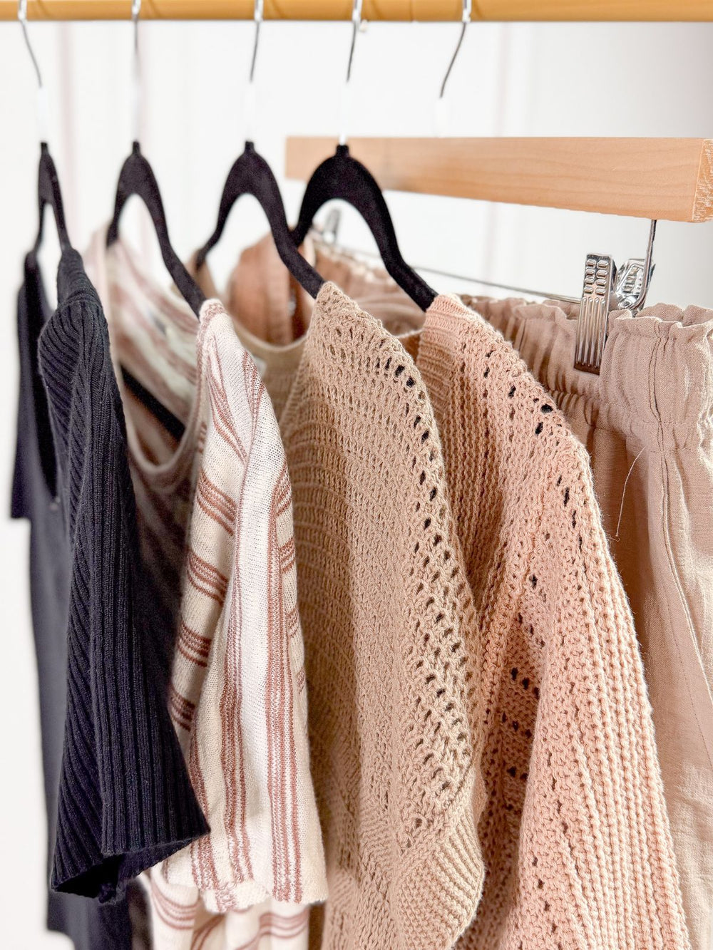 Neutral tops on and shorts on a gold rack.