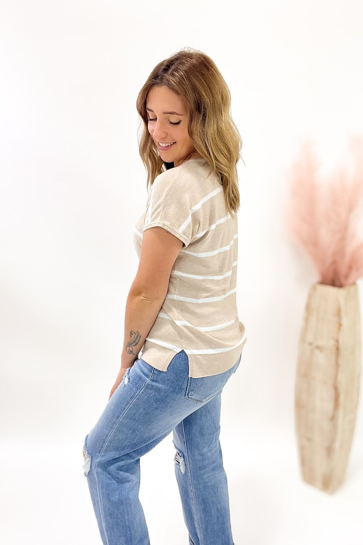 Woman wearing a striped shirt and jeans on a white background