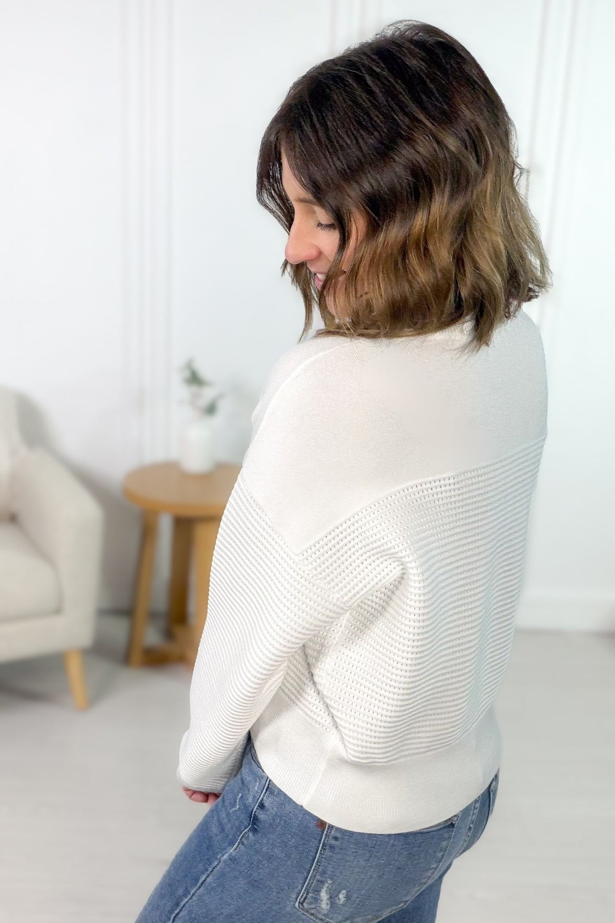 Off-white textured rib half zip pullover styled with denim jeans