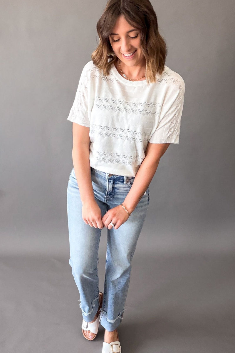 Woman wearing an off white pointelle knit short sleeve top with lightweight soft fabric and stretch, casual versatile women’s top