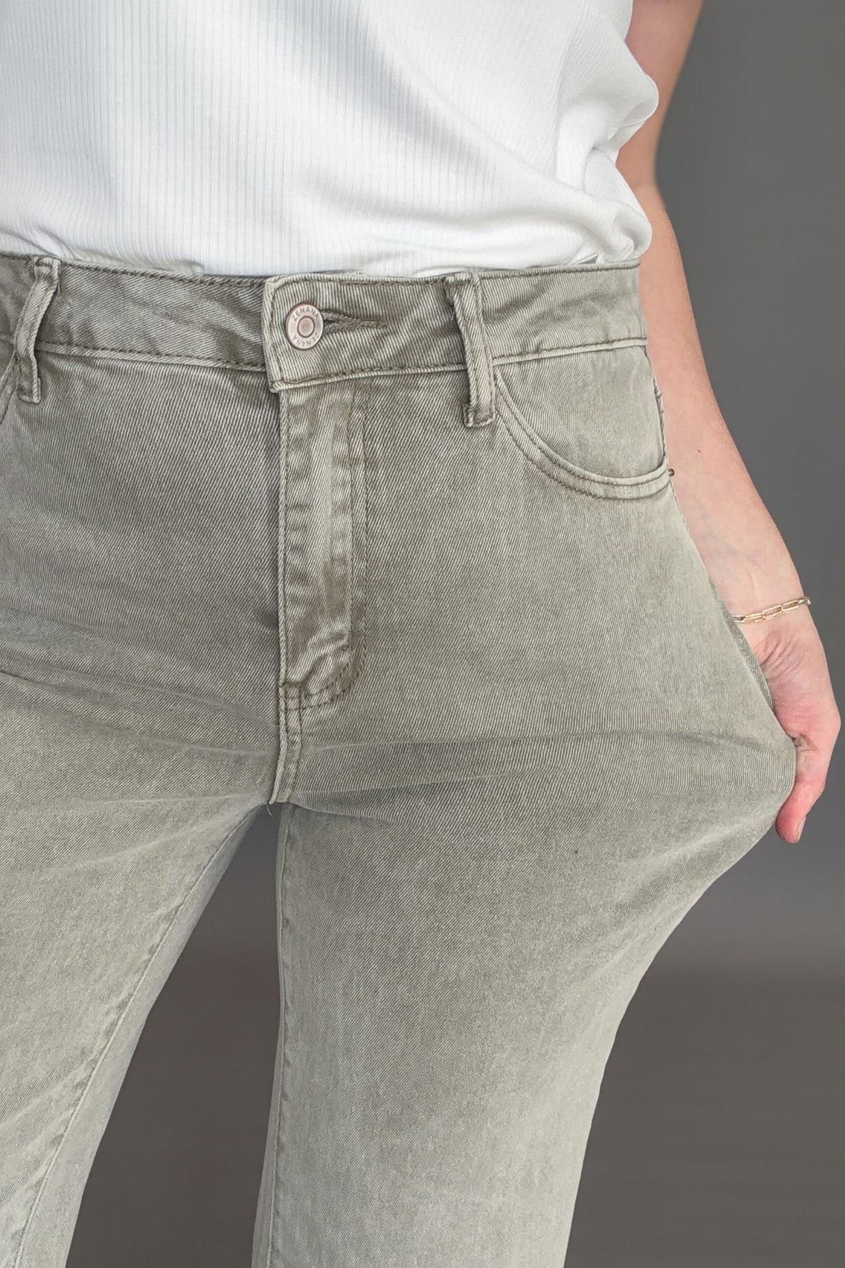 Close up of olive high rise crop boot jeans showing texture and stretch.