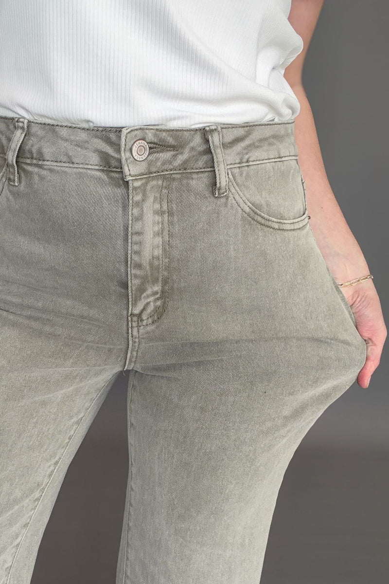 Close up of olive high rise crop boot jeans showing texture and stretch.