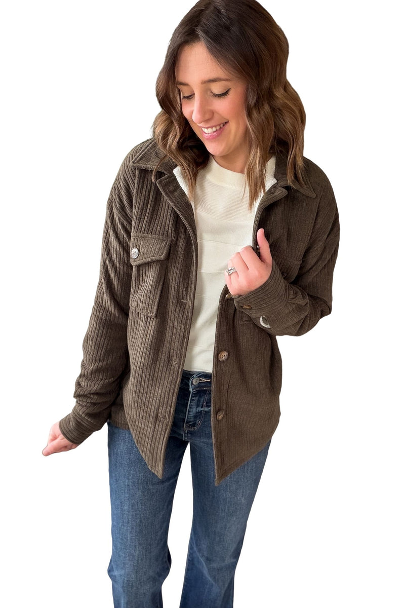 Woman wearing a Olive corduroy jacket  with sherpa lining on a white background