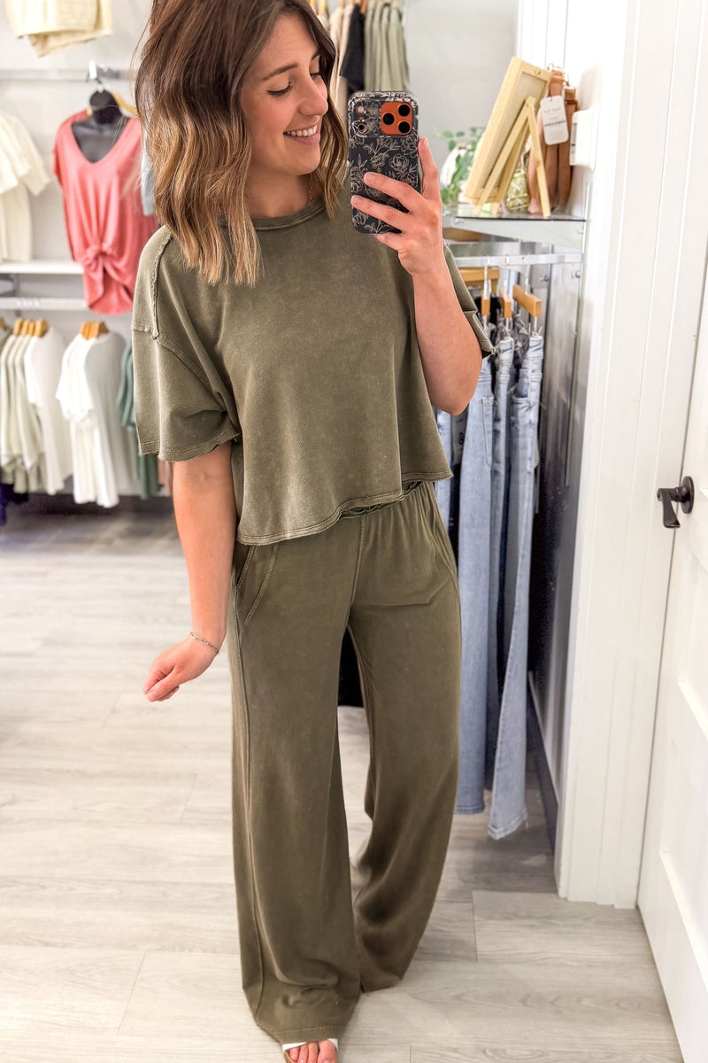 woman taking a mirror selfie wearing a matching set olive lounge pants and a short sleeve