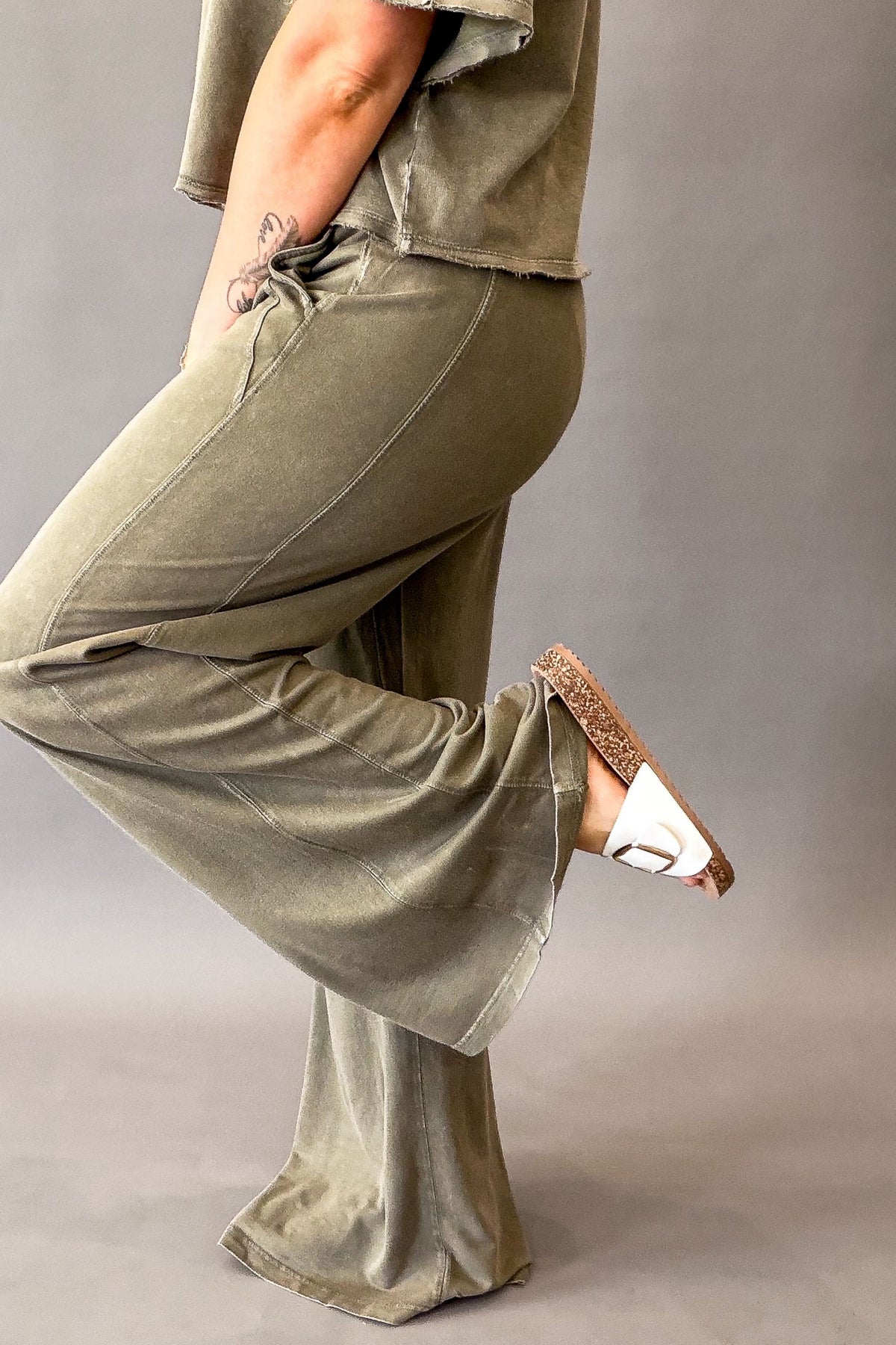 woman wearing a soft olive wide leg pant showing the side details
