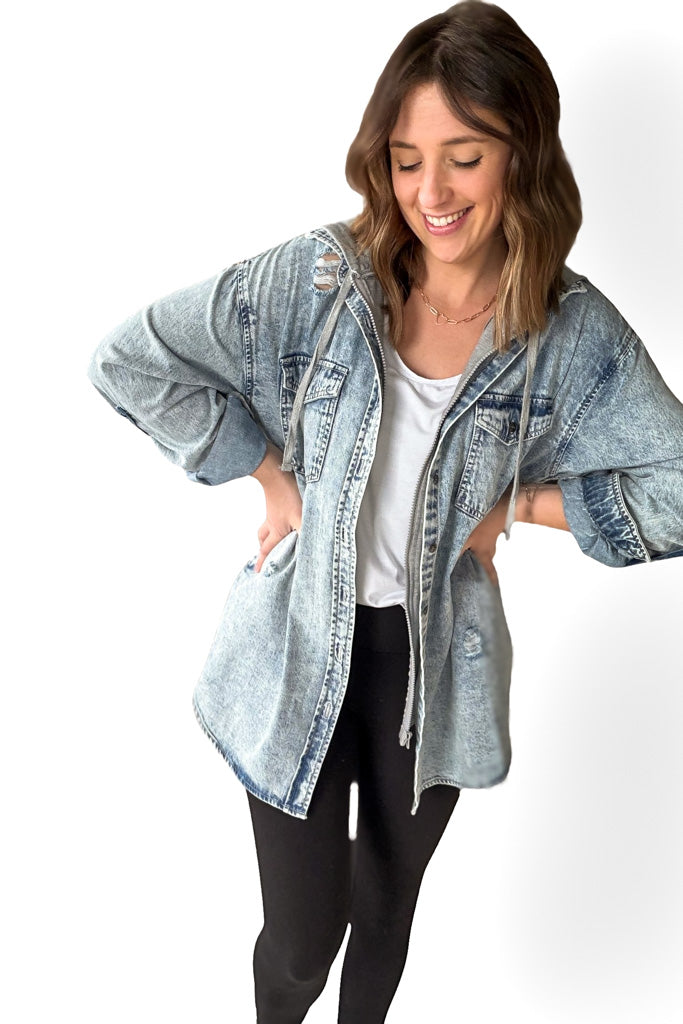 Woman wearing a light blue denim jacket on a white background