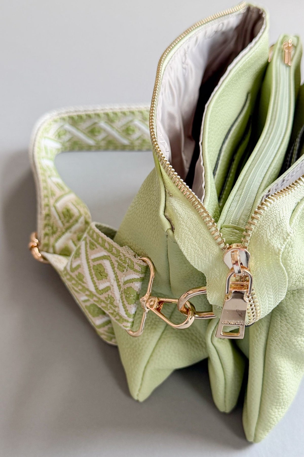 womens pale lime crossbody with removable guitar strap and clutch strap- vegan leather against a grey background
