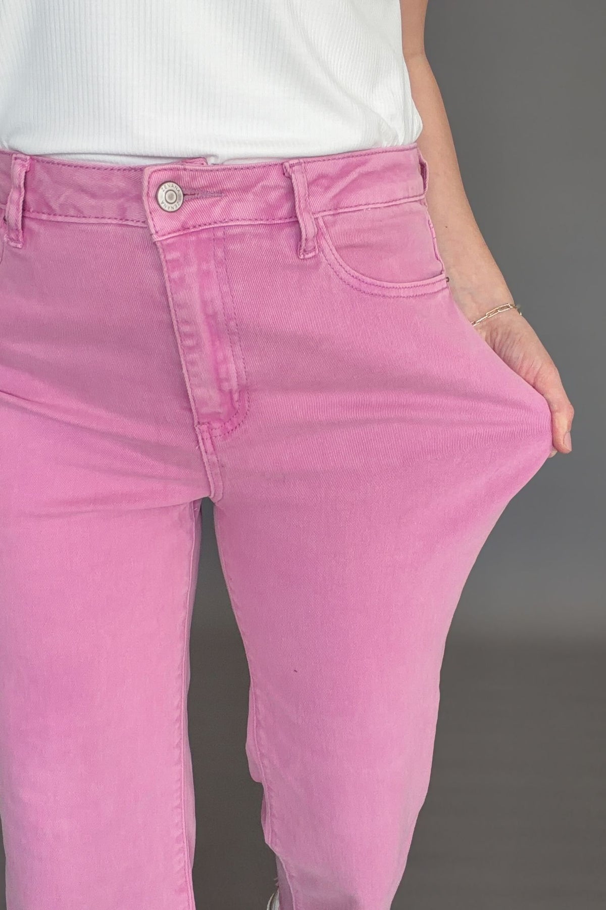 Close-up of soft pink acid wash denim fabric with vintage finish and structured stretch.