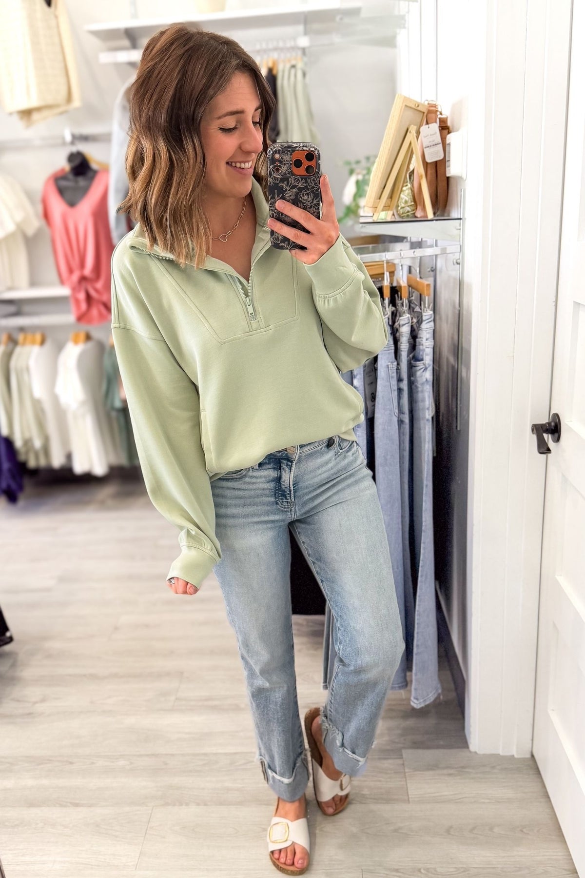 woman taking a selfie wearing blue jeans and white sandals