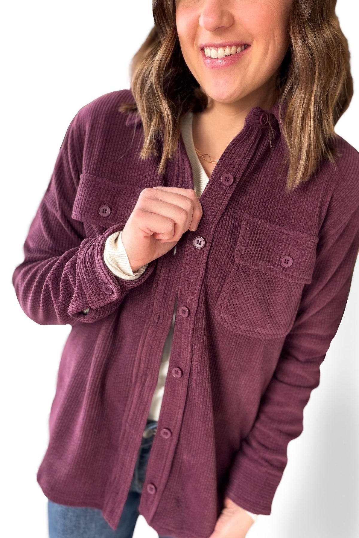 Person wearing a plum jacket on a white background
