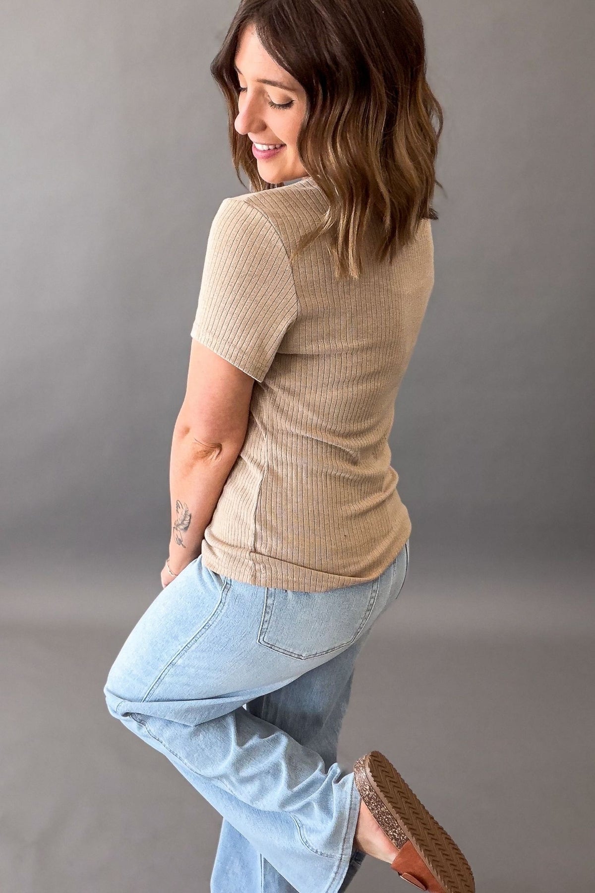 woman wearing a Soft biscuit neutral fitted knit top showing the back details