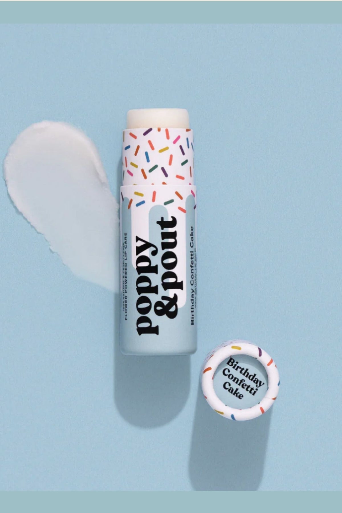 Lip balm with 'Poppy & Pout' branding on a light blue background