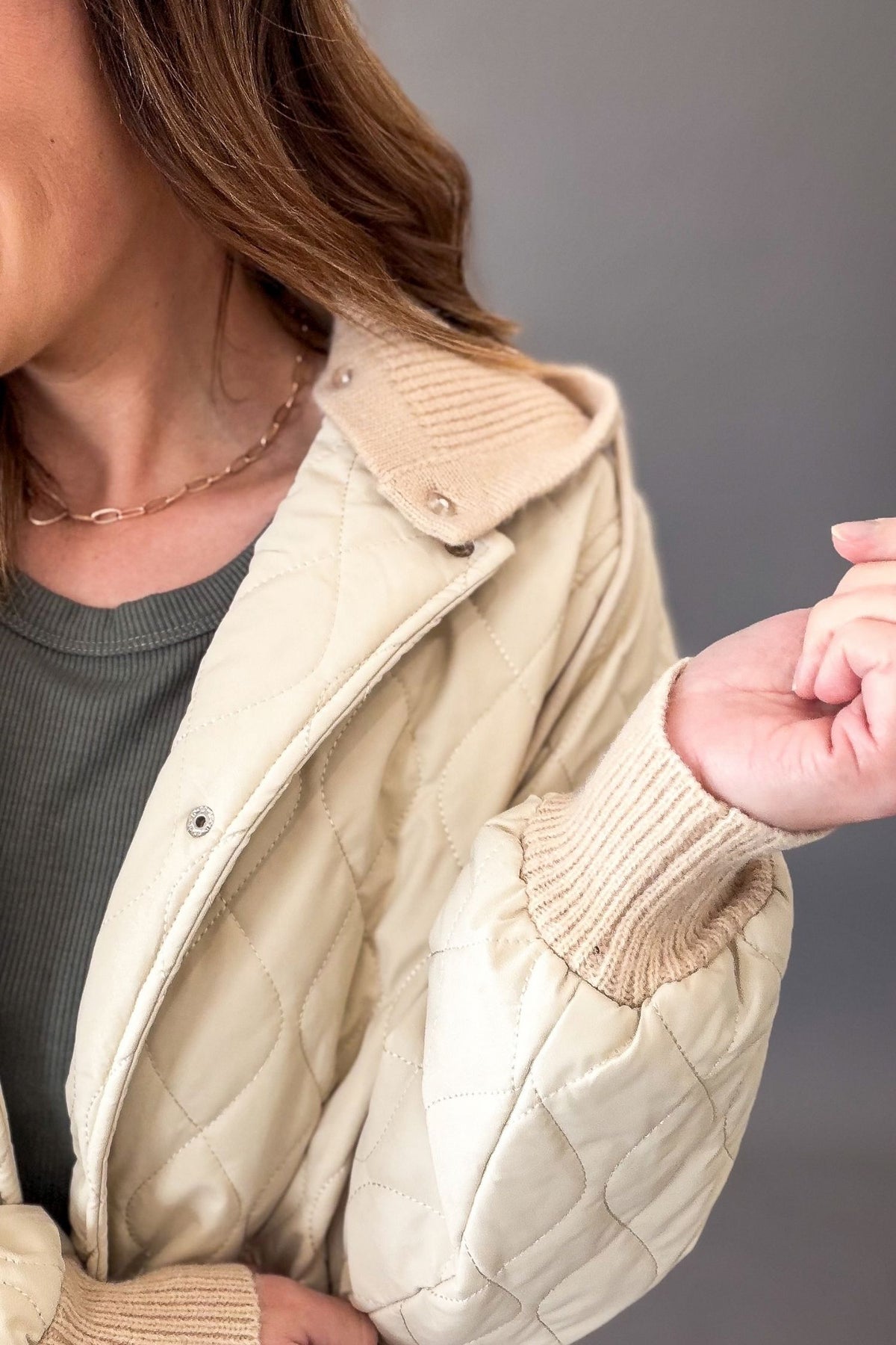 close up of a quilted natural jacking showing buttons for hood removal.