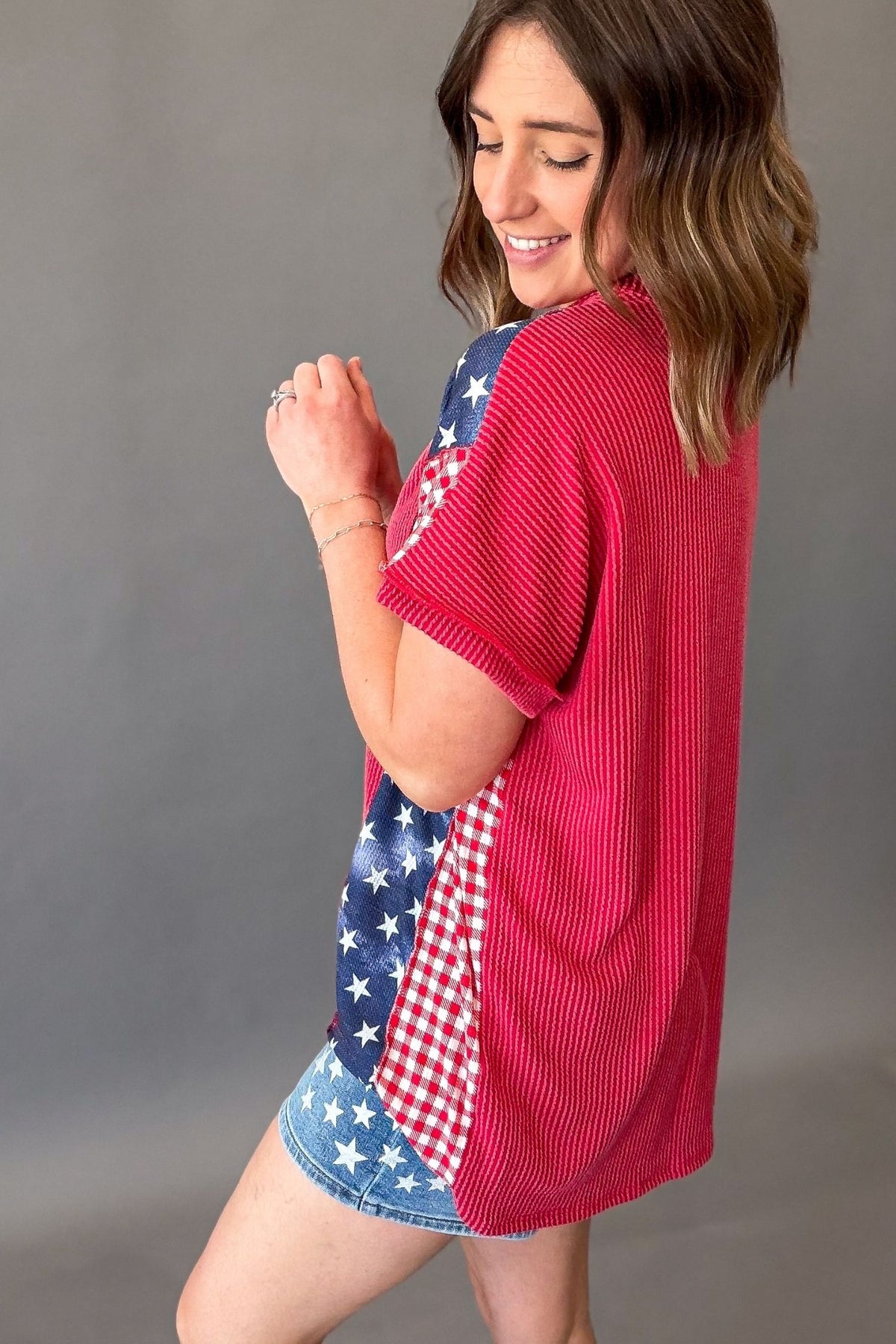 woman wearing a americana ribbed short sleeve showing the back solid color ribbed texture top