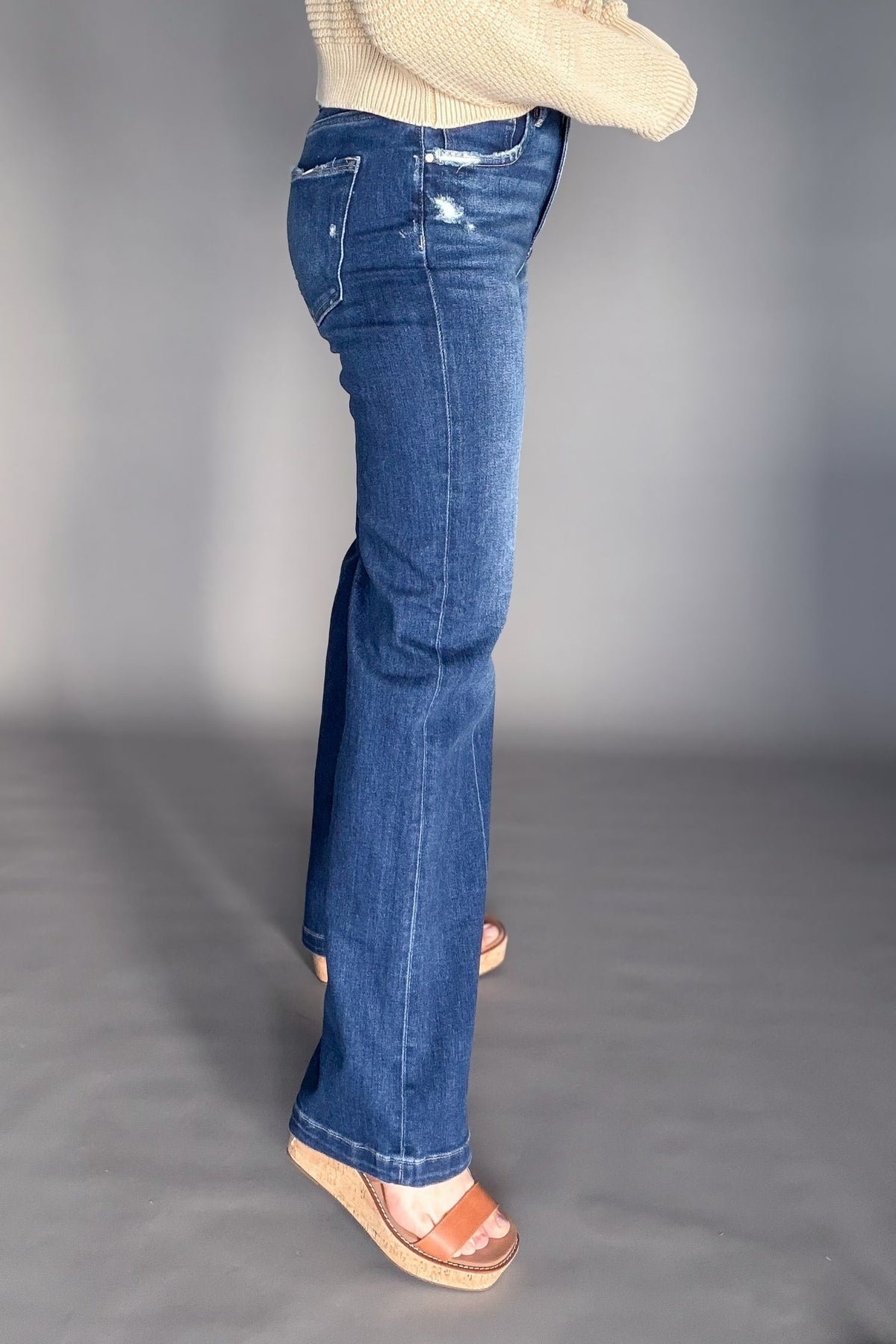 Blue jeans worn by a person on a gray background