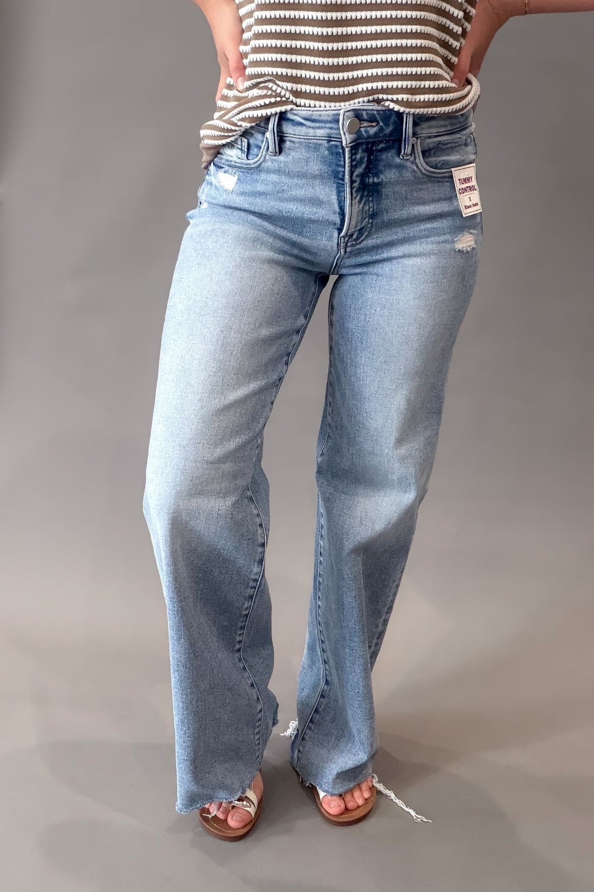 woman wearing a pair of risen light wash tummy control jeans with a raw hem