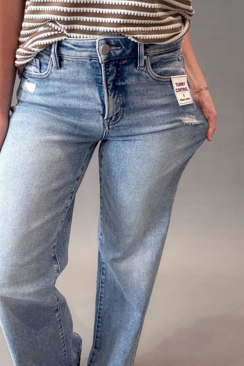 woman wearing a light distressed pair of jeans showing stretch in the denim