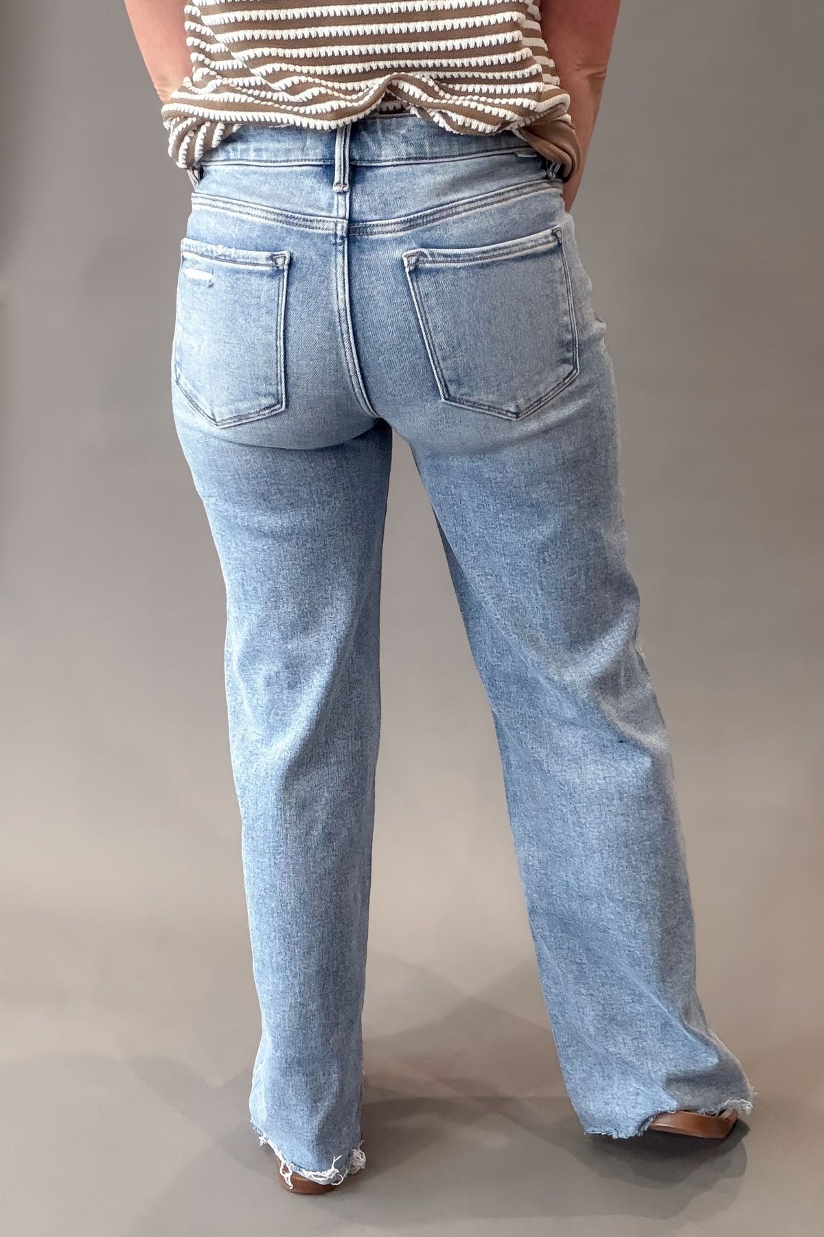 woman wearing a pair of mid rise risen jeans showing the back details