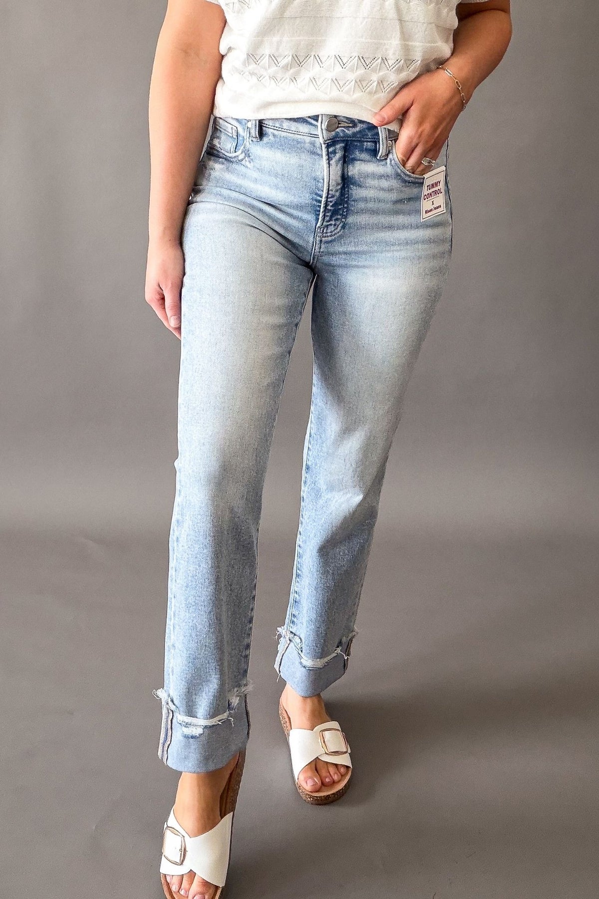 Woman wearing Risen high rise tummy control straight leg jeans with cuffed hem, light wash cropped denim for women