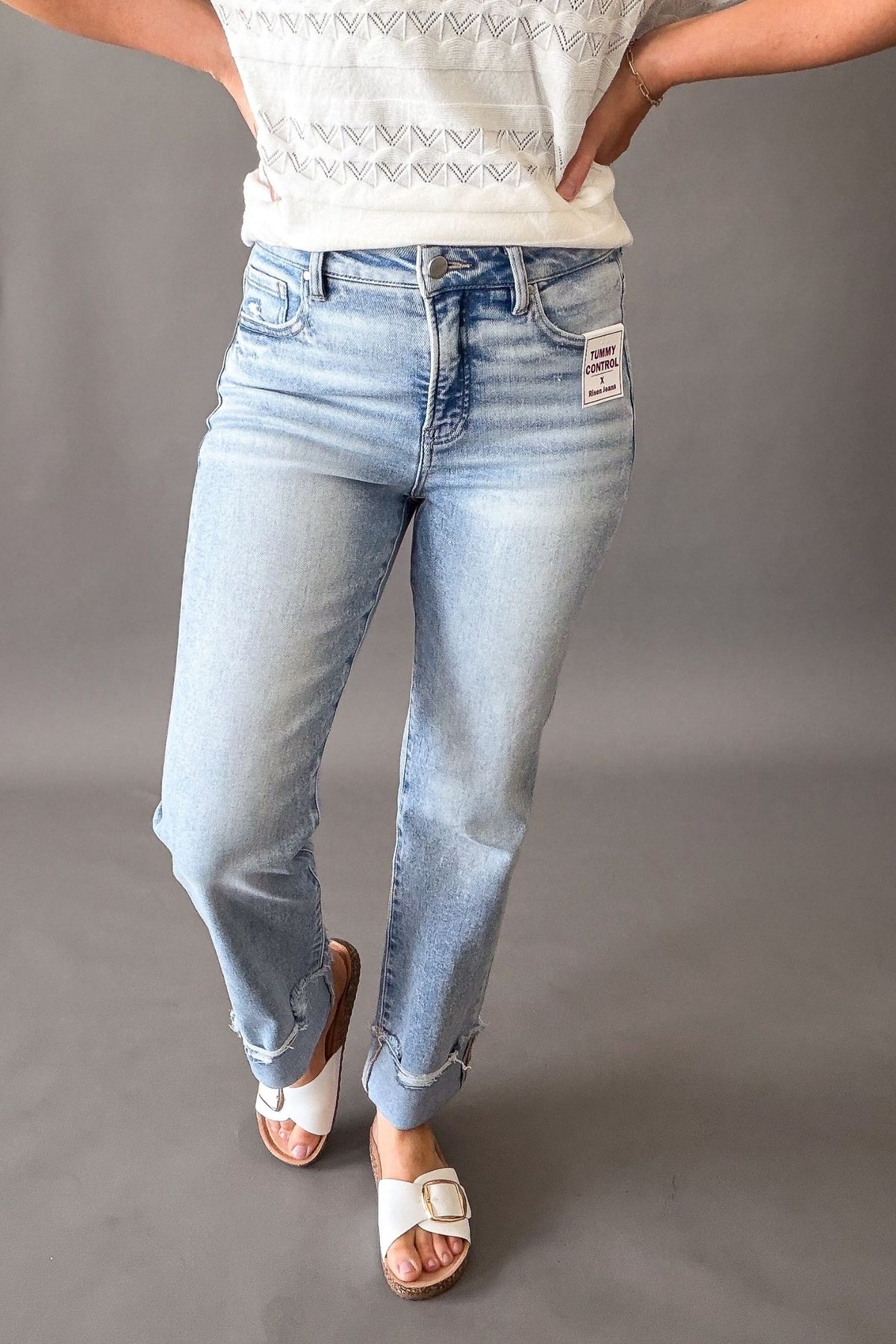 Woman wearing Risen high rise tummy control straight leg jeans with cuffed hem, light wash cropped denim for women