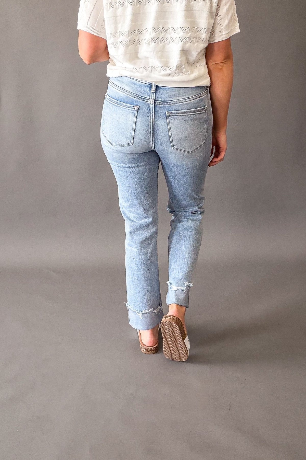 Woman wearing Risen high rise tummy control straight leg jeans with cuffed hem, light wash cropped denim for women showing the back details
