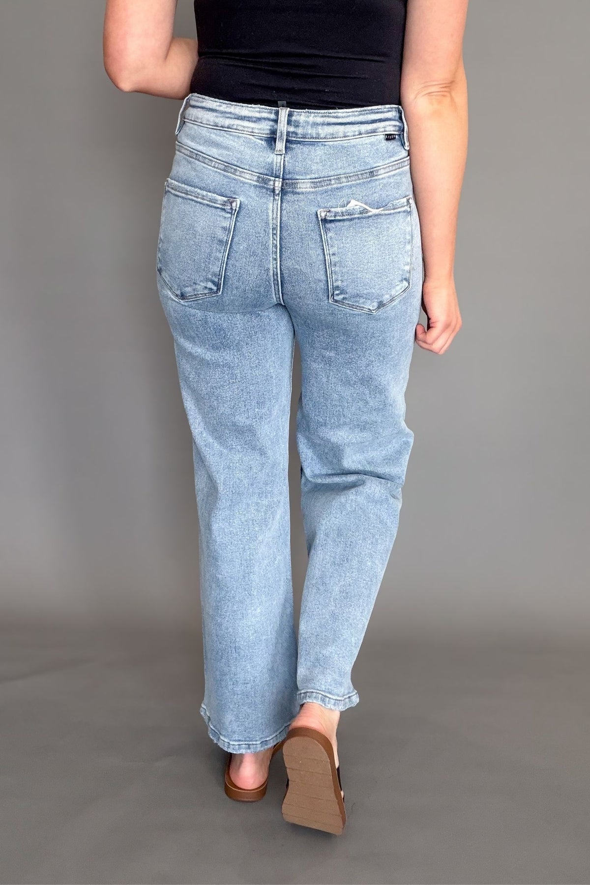 light wash cropped wide leg jeans styled with black tank and sandals showing back details