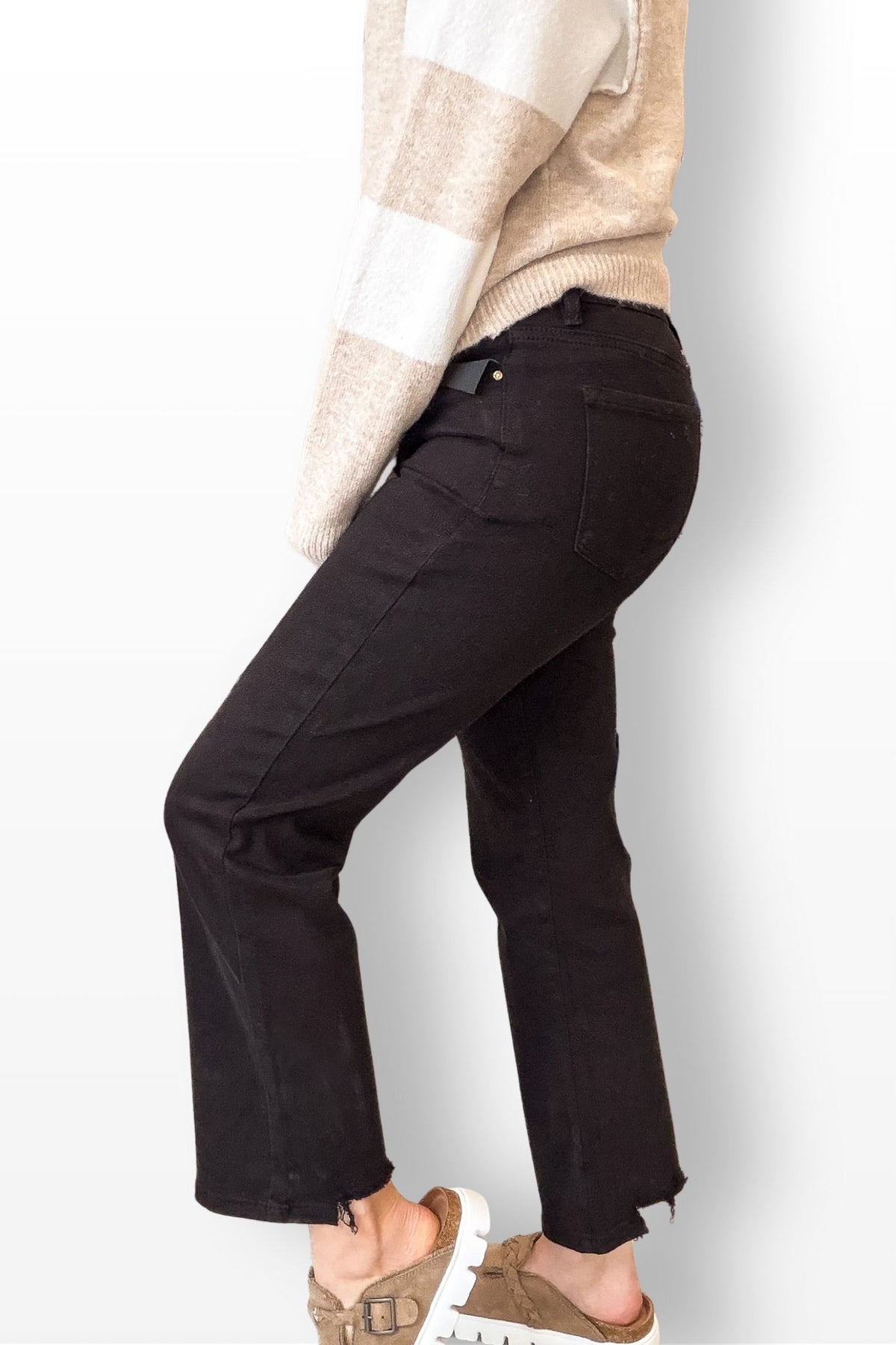 Dark pants worn by a person on a light gray background