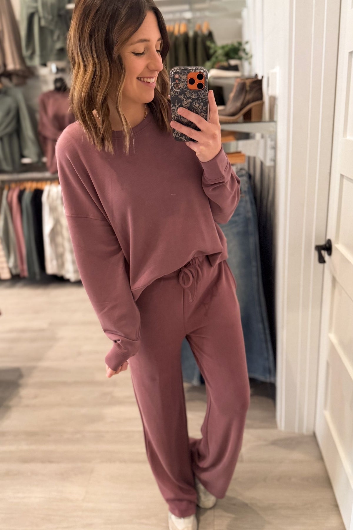 Woman taking a mirror selfie wearing a rose lounge set.