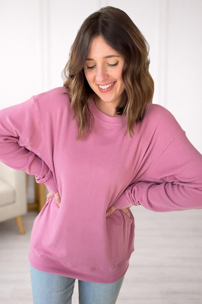 Woman wearing a pink pullover in a casual setting
