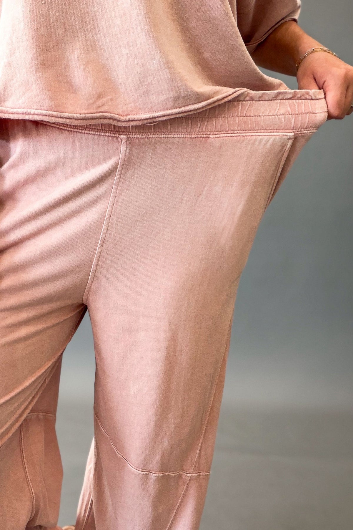woman wearing pink jogger pants showing the stretch in the waistband