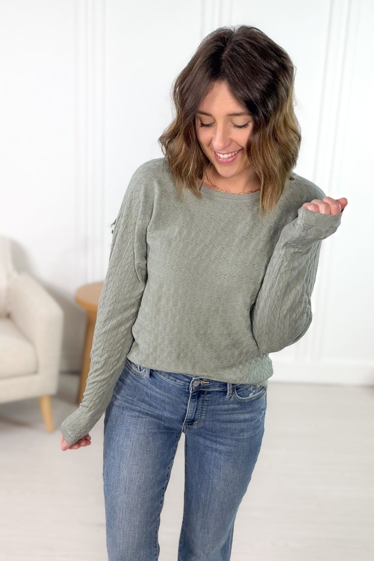 Sage diamond pattern sweater with scalloped details styled with blue denim jeans