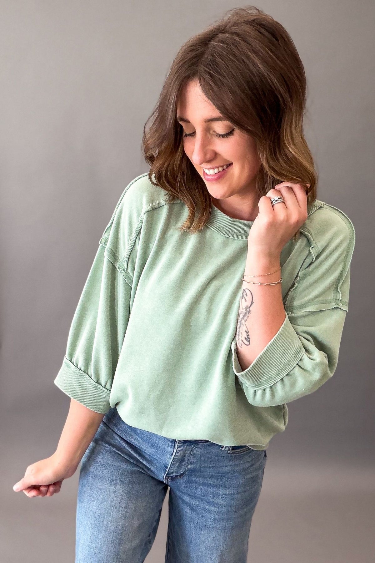 woman wearing a sage french terry relaxed fit top