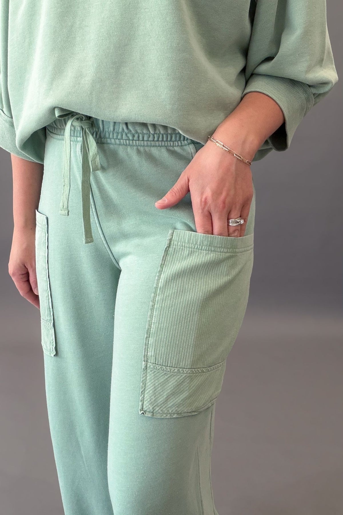 woman wearing a stretchy drawstring pant with large side pockets and a matching top