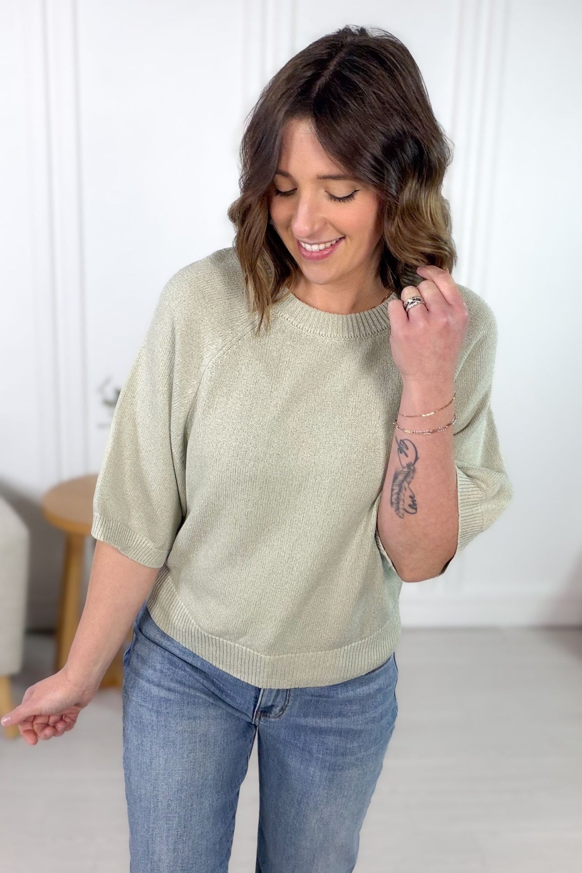 Sage green textured knit sweater top styled with denim
