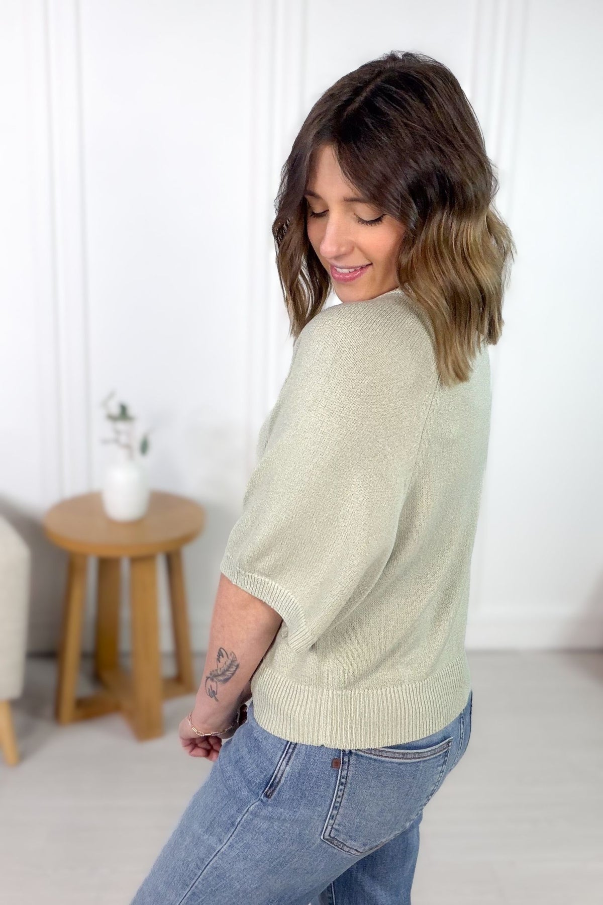 Lightweight sage sweater with short sleeves and structured feel