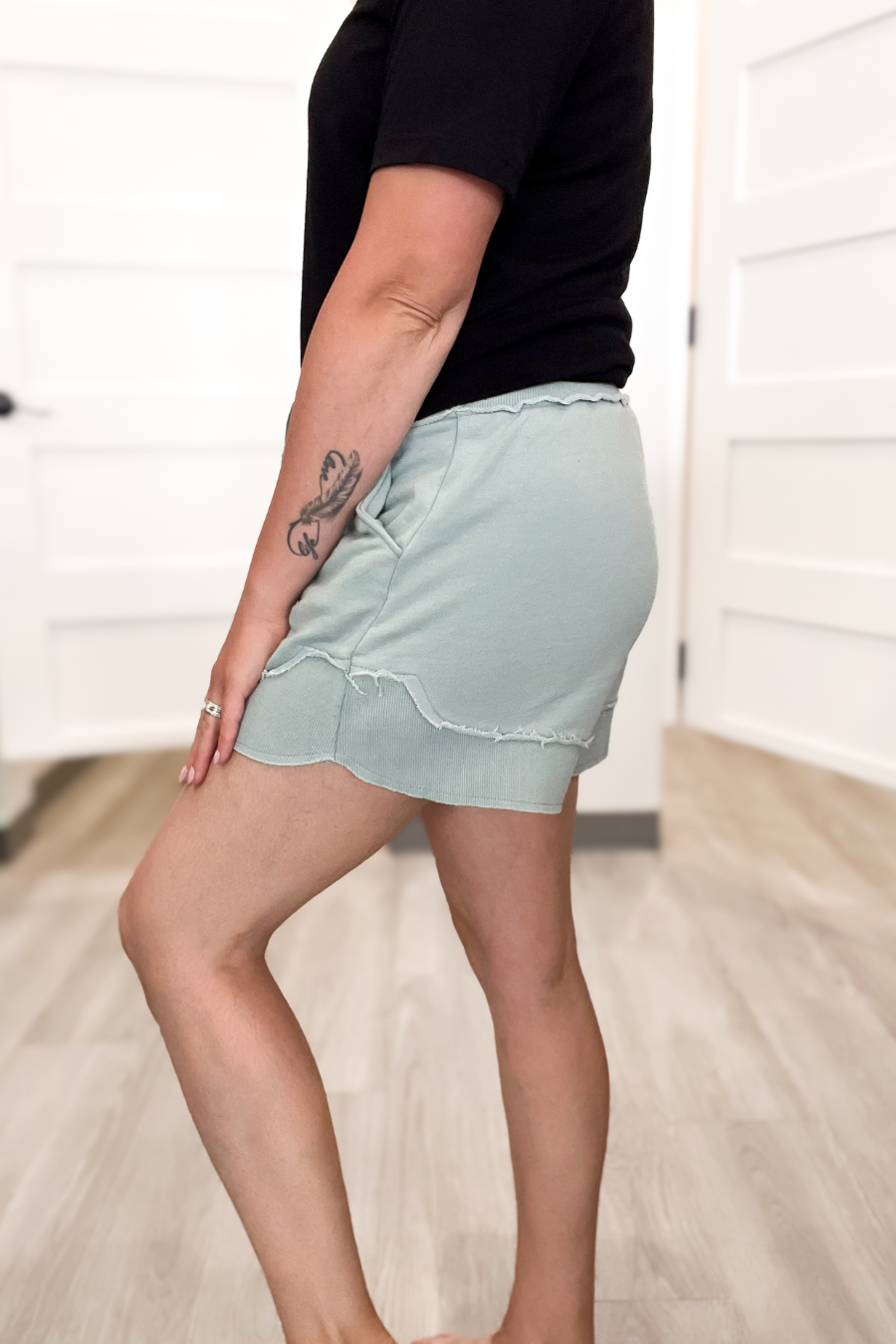 Person wearing a light blue skirt and black top indoors.