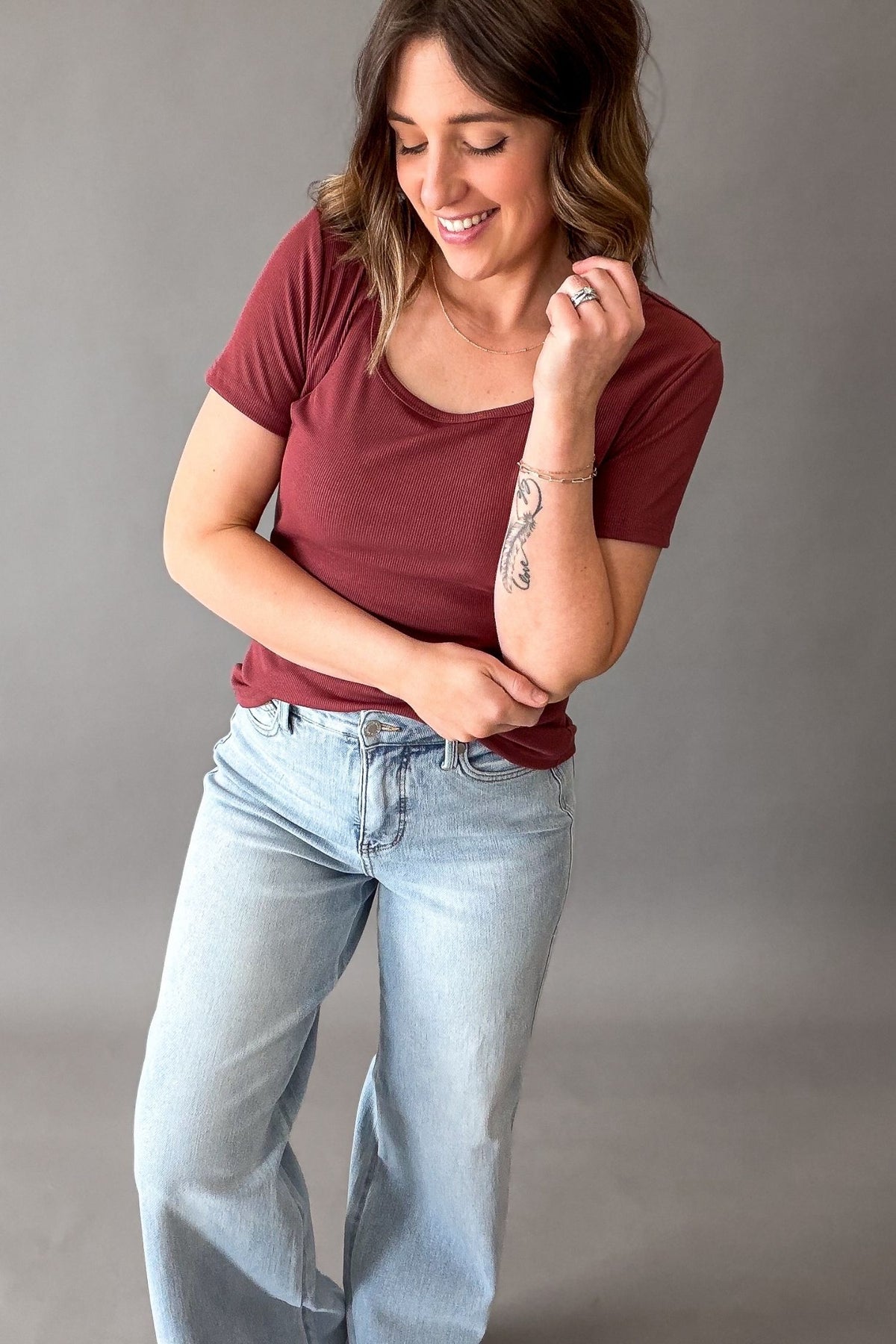 woman wearing a garnet colored textured basic short sleeve with light wash jeans