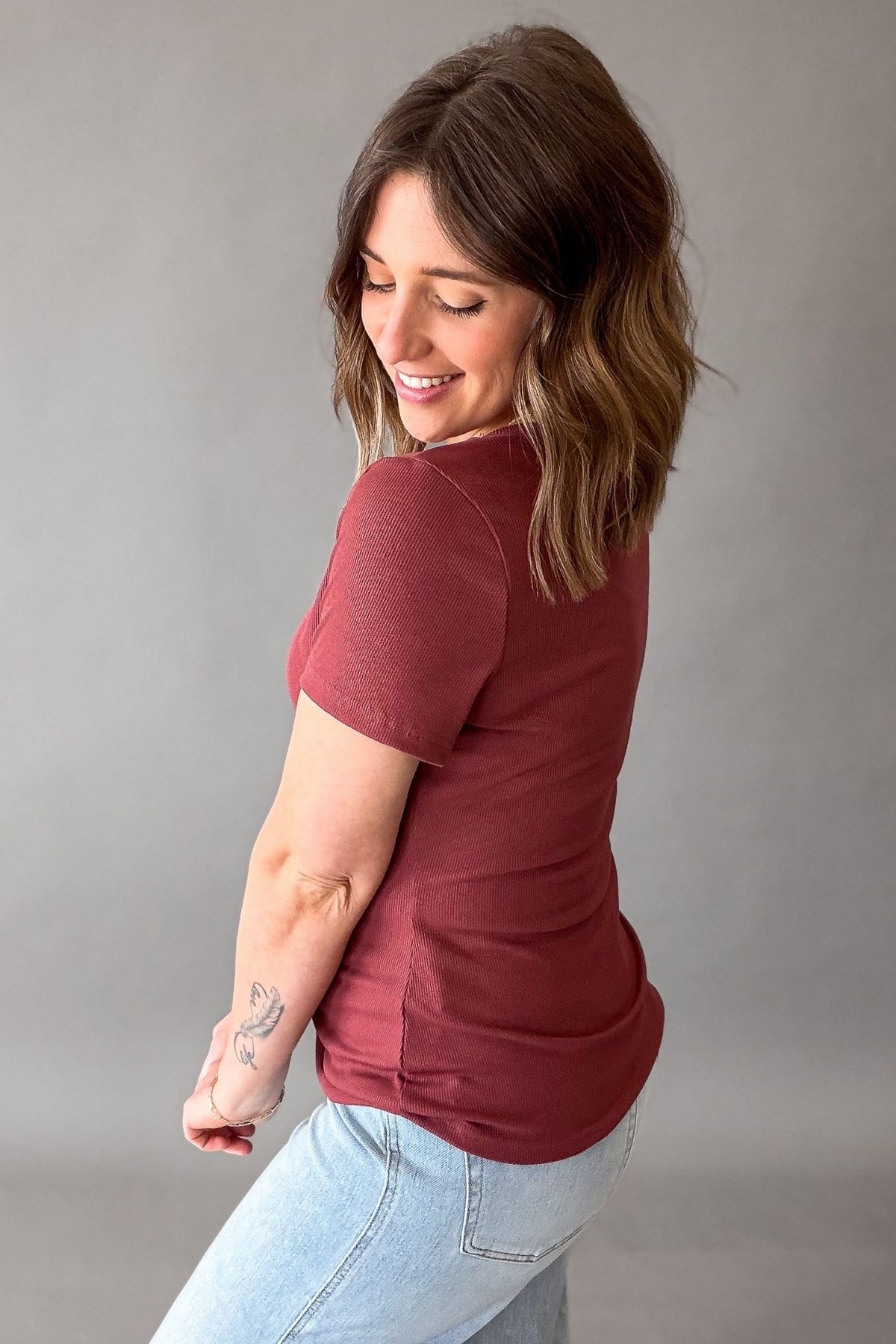 woman wearing a garnet basic tee showing side details 