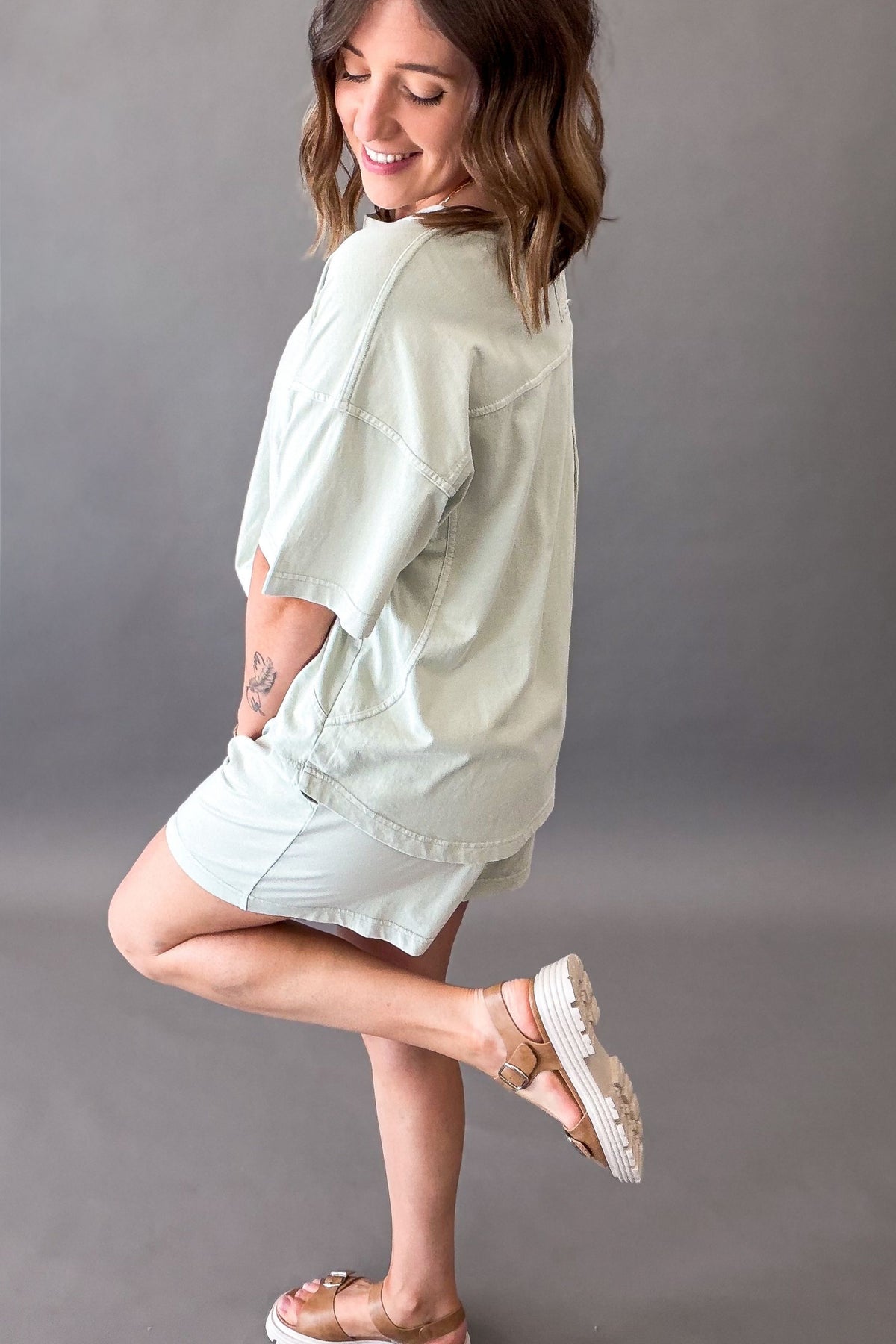 woman wearing a soft mint oversized t-shirt and shorts showing side and back details