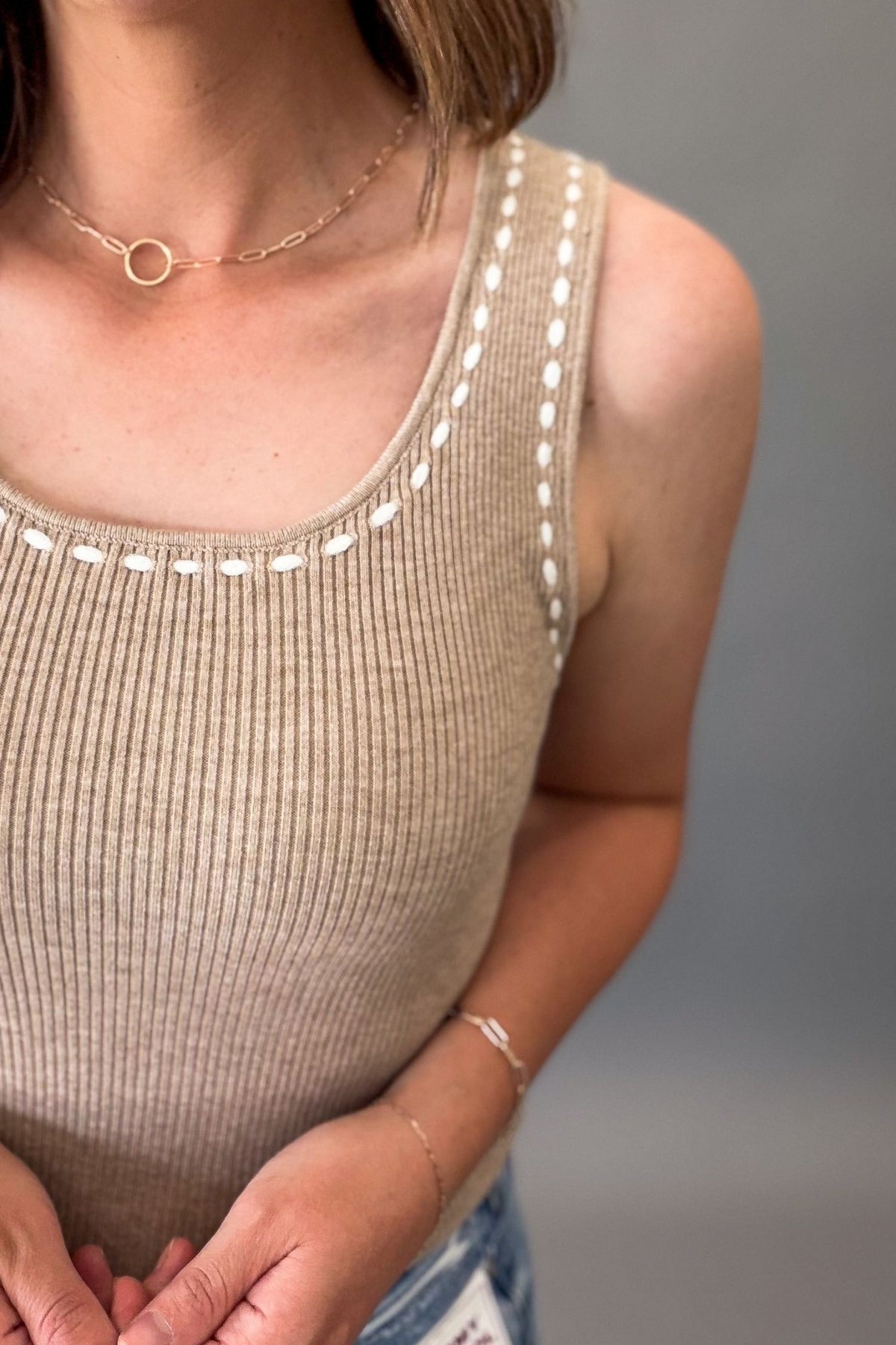 close up of a woman wearing a soft mocha contrast stitch sweater tank showing the ribbed texture.
