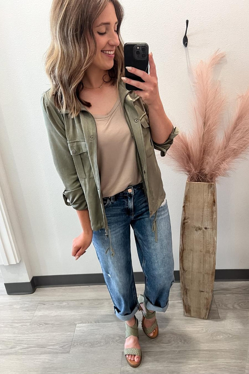 Woman taking a selfie in a casual outfit with a plant in the background