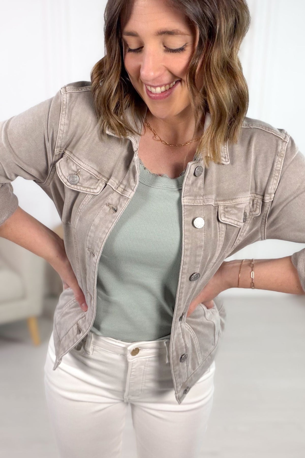 Woman wearing a light stone denim jacket showing a close up of the details.