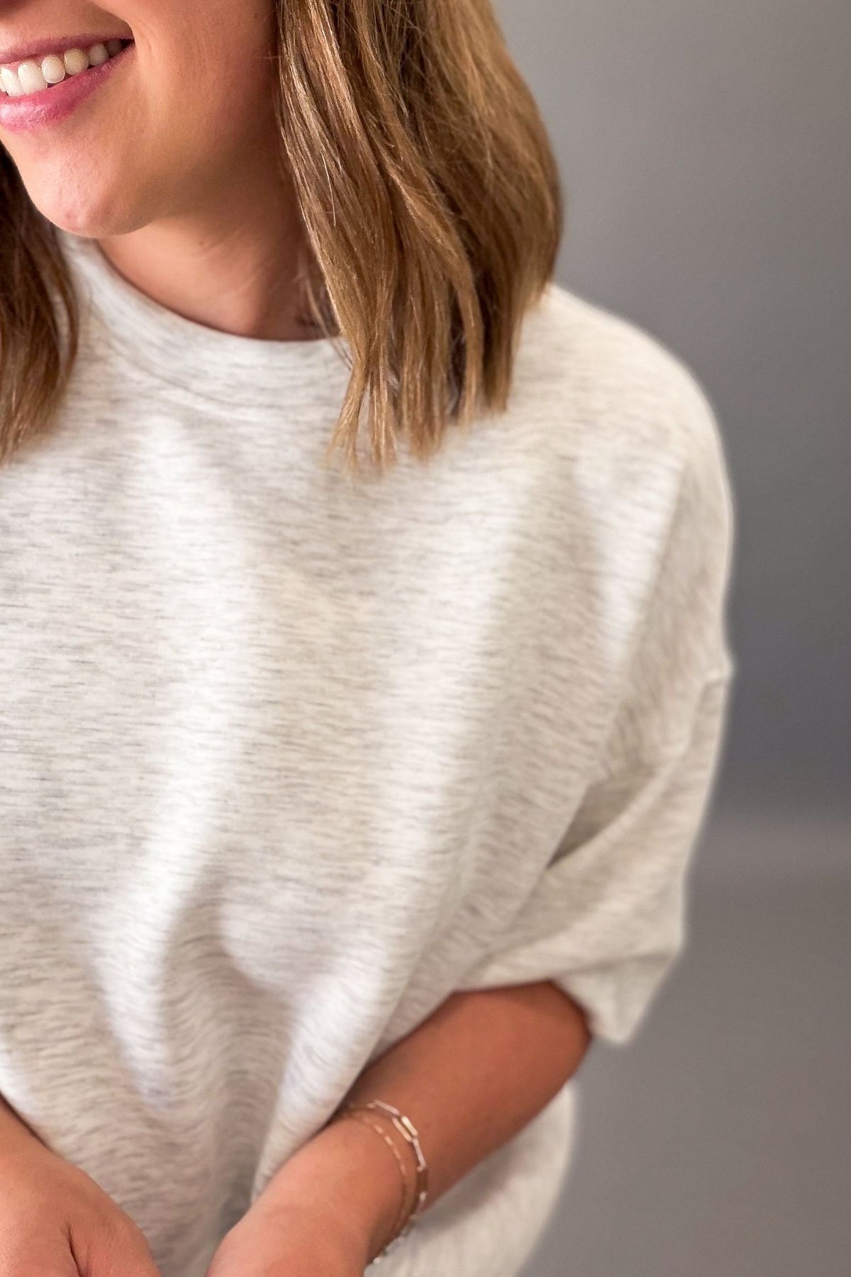 woman wearing a light grey lounge short sleeve top showing the heathered details