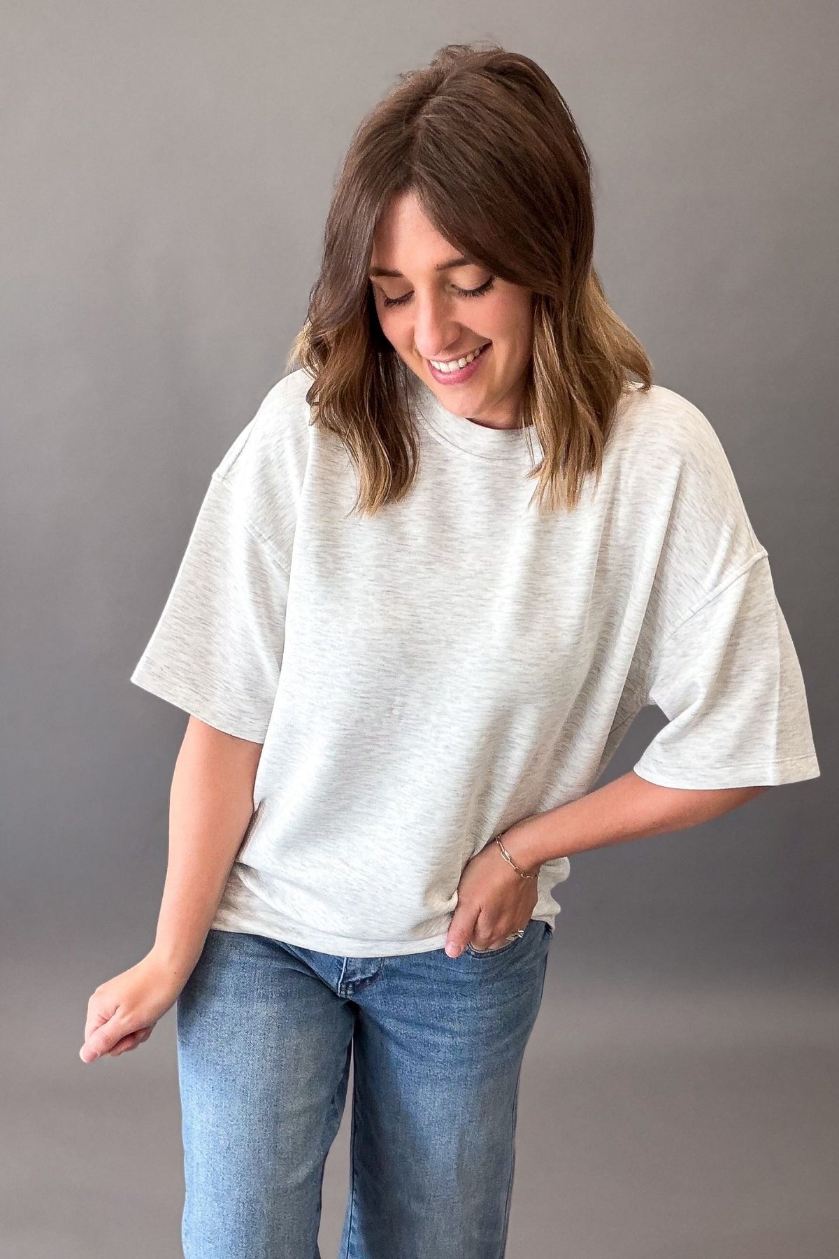 woman wearing a relaxed casual heather grey drawstring short sleeve