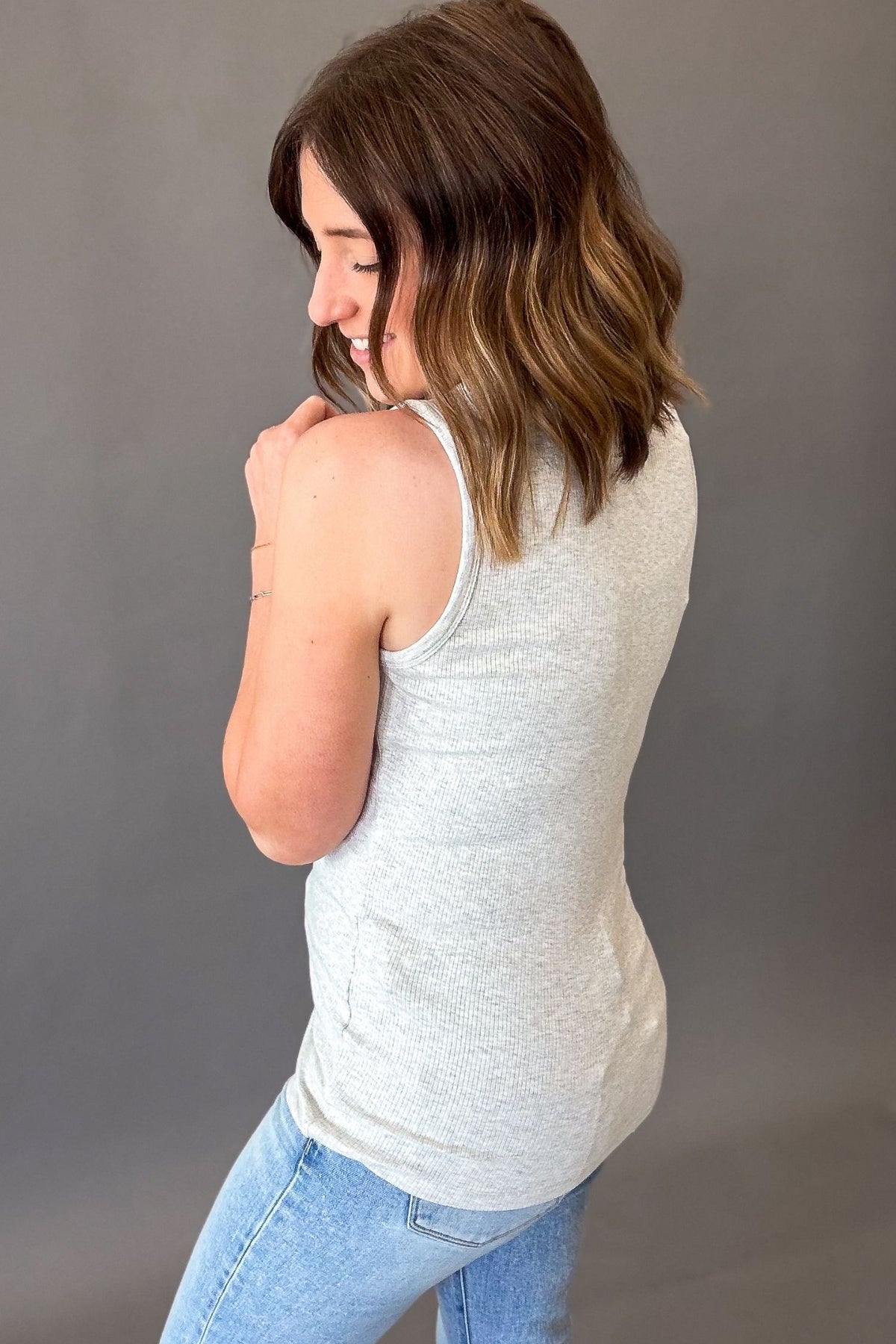 woman showing back coverage details of the heather grey tank with ribbed texture