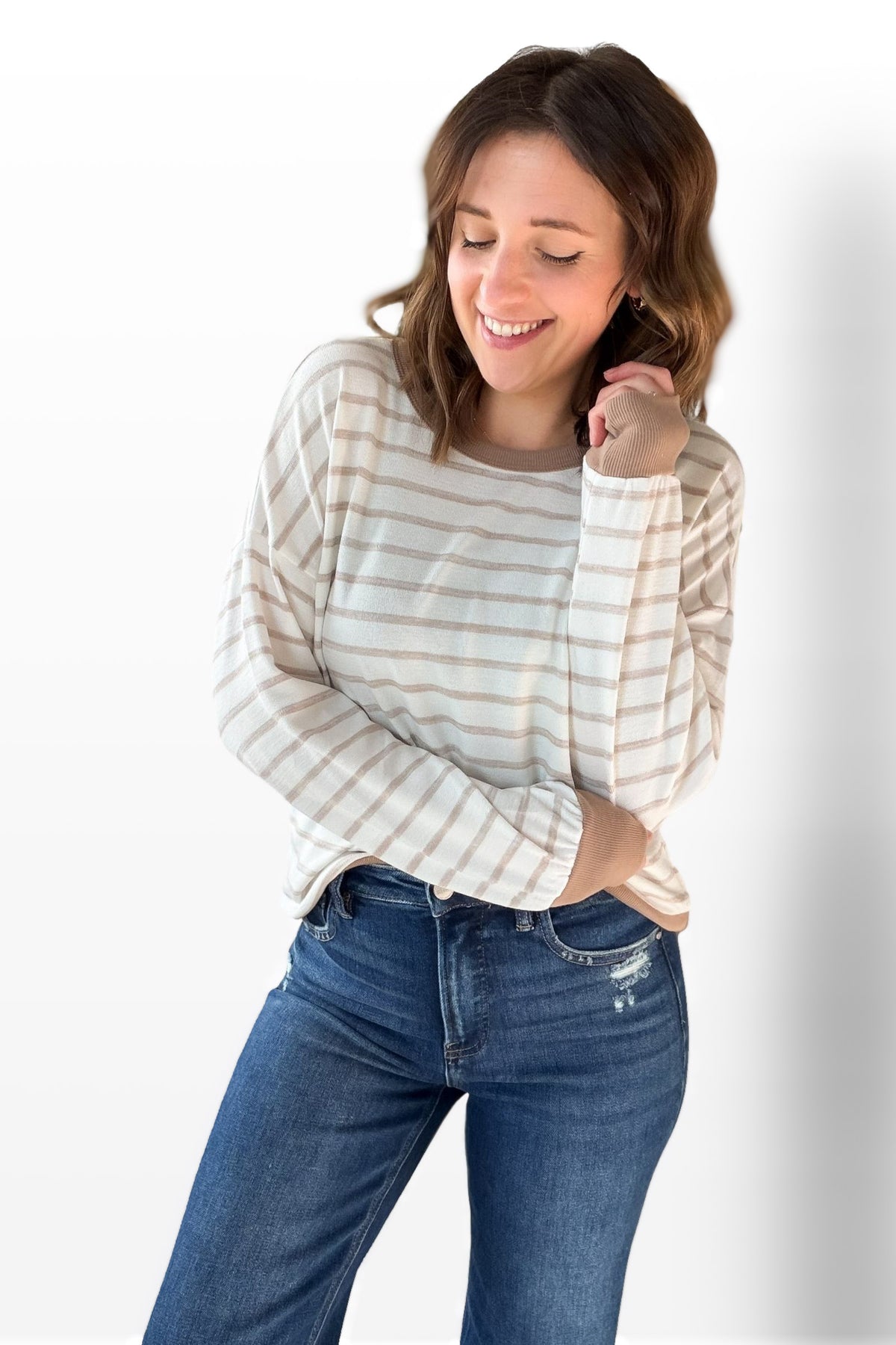 Woman wearing a striped shirt and blue jeans on a white background