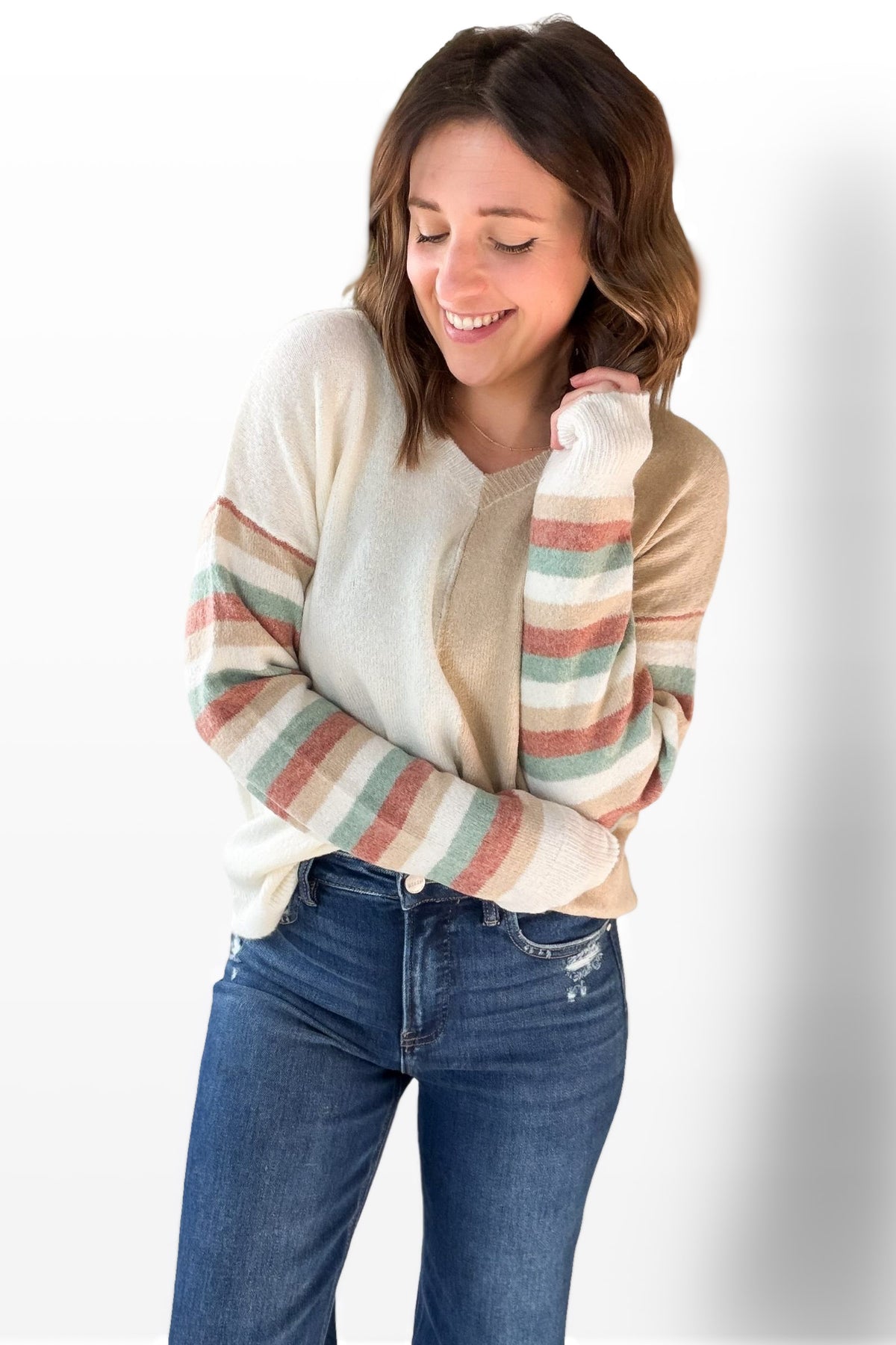 Woman wearing a striped sweater and jeans on a white background