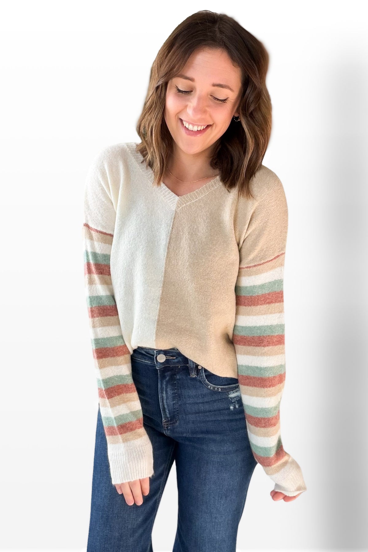 Woman wearing a striped long-sleeve top with a plain background