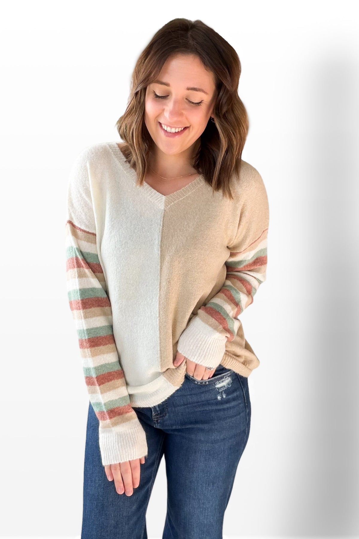 Woman wearing a striped sweater with a plain background