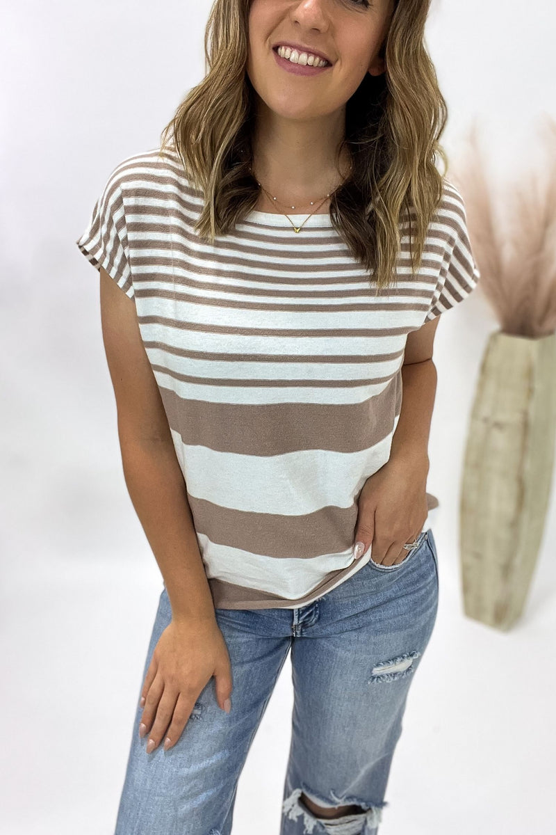 Woman wearing a striped shirt and jeans against a white background